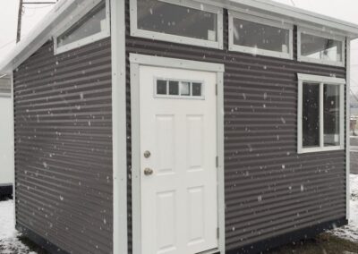 10x12 Modern Building Dark Gray with White Trim. 3’ 4 Lite Door and 3’x3’ Double Pane Window